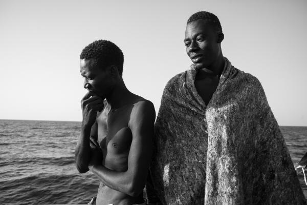 Banjul to Biella - Mbeye, from Senegal, and Malick, from Gambia, look at the sea from the rescue vessel Iuventa....