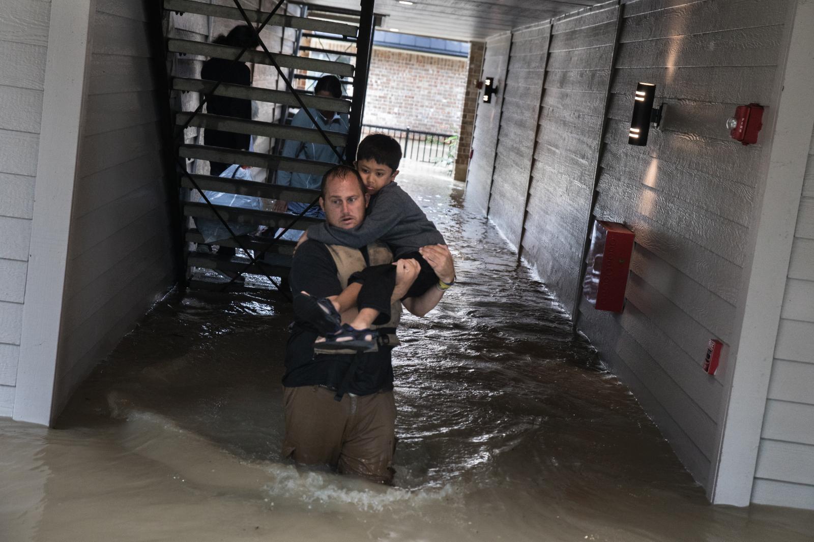 Dustin Langley helps evacuate a...ed apartment in Kingwood, Texas