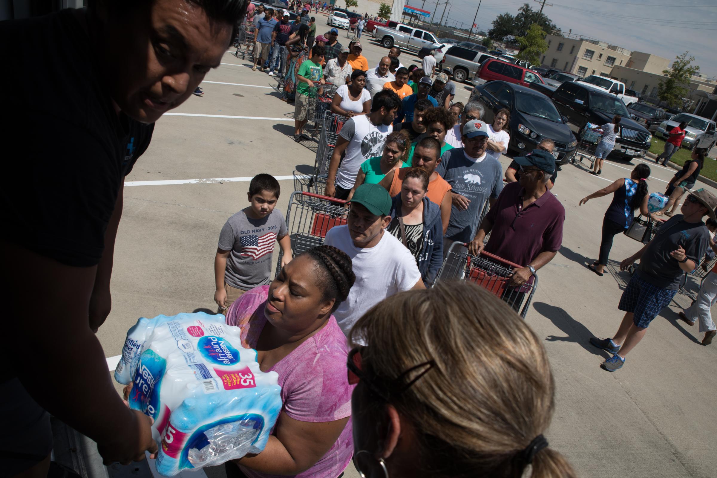 Hurricane Harvey - Residents line up for free water with the city of...