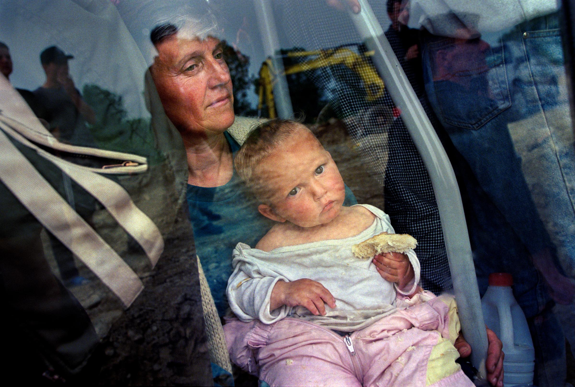Senokes Refugee Camp, Macedonia, Published May 23, 1999 Refugees wait to be unloaded in the Senokos refugee camp in Macedonia after a journey from...