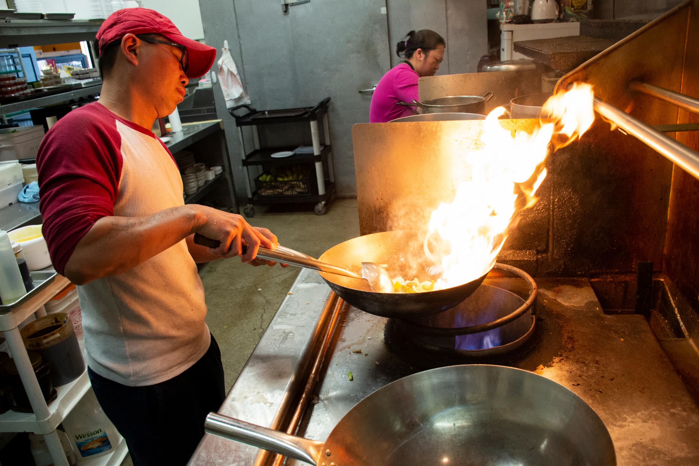 A Taste of Home - Tiger Chef owner Sai Tai cooks fried rice on a wok for a...