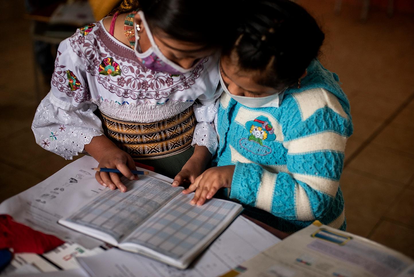 Two Karanki indigenous girls are studying together during their classes in the San Clemente...