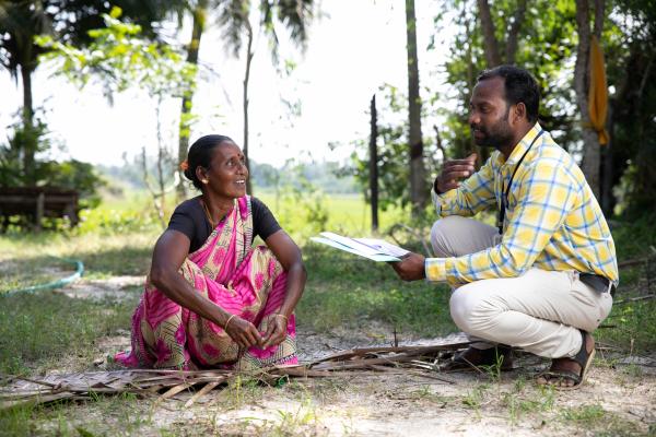 NAGAPATTINAM, INDIA (01/06/2022) - Kalimuthu Venkatesan (right), field officer, LaRaksha Social Impact Trust interacts with Tamilarasi Kamaraj (left) a beneficiary, of LaRaksha Social Impact Trust's Roofing Loan and her son Rajakumaran Kamaraj about the new construction of house in Nagapattinam. LaRaksha identified the need for strong roofing solutions, combined with dedicated roofing loan products. Roofing is a cause of concern for the entire sample of the population living along the coast, as people’s roof is destroyed in reoccurring annual, strong winds, severe rainfall and cyclone. That is why their is a general need for mid-to-long-term roofing solutions in coastal areas. LaRaksha in designing and pilot testing a unique roofing loan product, able to cater to both mid-and-long-term roofing requirements of the community. 