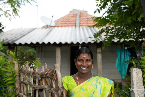 THIRUVARUR, INDIA (01/06/2022) - Vetriselvi Muthuramalingam, beneficiary, LaRaksha Social Impact Trust's Roofing Loan stands in front of her house whose roof has been replaced with a better and stronger tile roofing in Thiruvarur. She used the loan to make improvements to her home. LaRaksha identified the need for strong roofing solutions, combined with dedicated roofing loan products. Roofing is a cause of concern for the entire sample of the population living along the coast, as people’s roof is destroyed in reoccurring annual, strong winds, severe rainfall and cyclone. That is why their is a general need for mid-to-long-term roofing solutions in coastal areas. LaRaksha in designing and pilot testing a unique roofing loan product, able to cater to both mid-and-long-term roofing requirements of the community. 