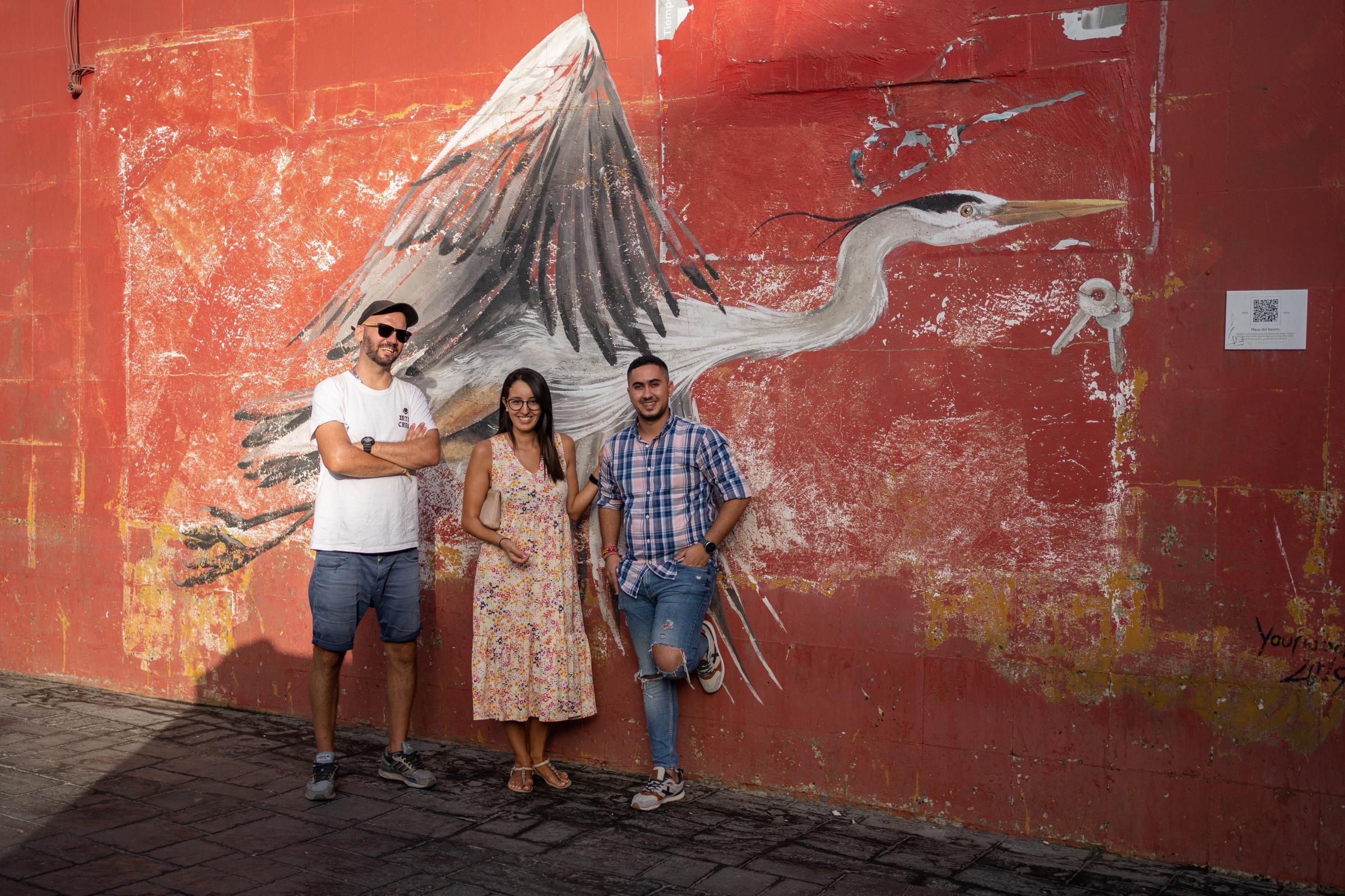  Francesco, Sheima y Mohamed posan para un retrato delante de un mural realizado en el marco de las actividades de la asociaci&oacute;n. 
