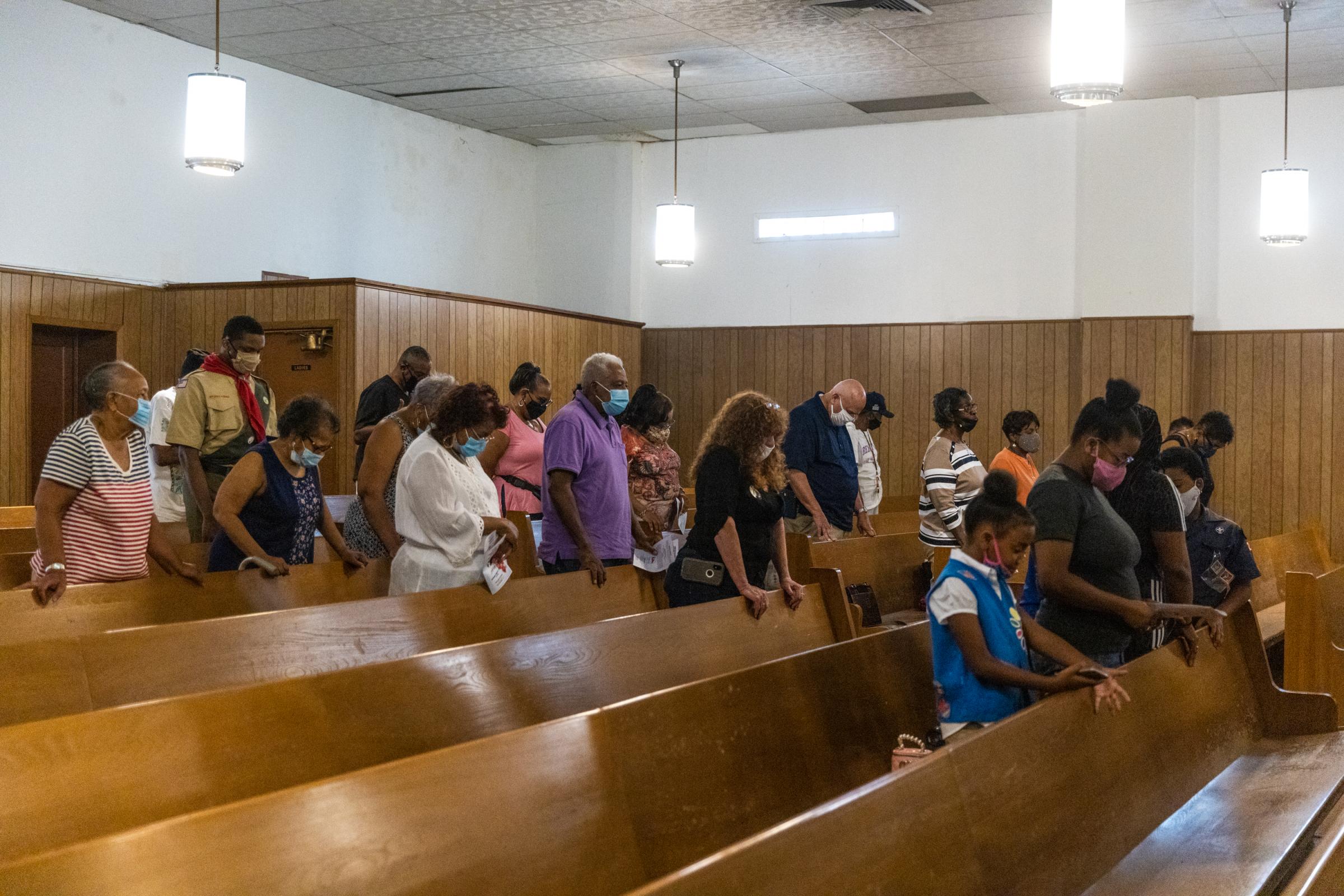 Members of the Turner Station community bow their heads in prayer during the closing ceremony of the 23rd annual Turner Station Heritage Praise Day &ldquo;Cell-A-Bration&rdquo; on August 7, 2021.