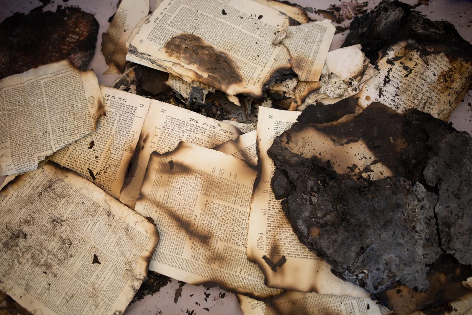 Burnt religious texts are piled...y of Lod, Israel, May 23, 2021.