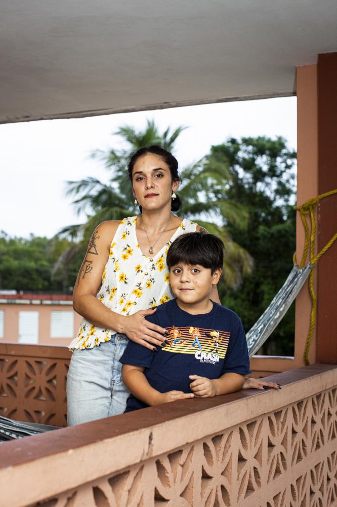 Ashlee Vega and her 7-year-old son pose for a portrait at their home in Aguadilla. The family&#39;s fridge broke down with the swarm of selective blackouts affecting the island that began after the privatization of the distribution system by LUMA. Sebastian says he gets scared when the power goes out, so he hides under the kitchen table. 2021   [The New York Times]