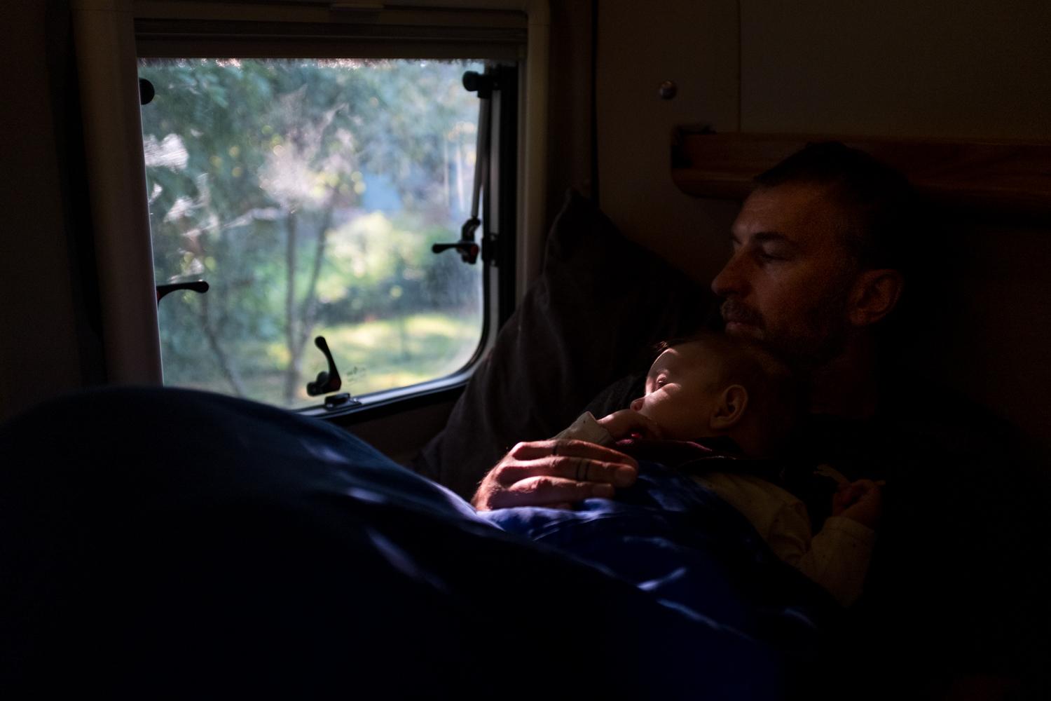 My partner Sebastian holds our six-months-old daughter Nia inside our camper van during a...