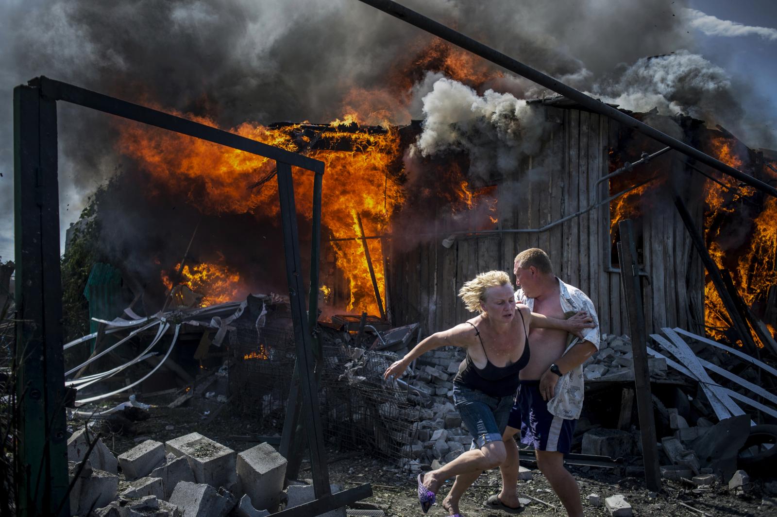 Civilians escape from a fire at...ttack in the Luhanskaya village