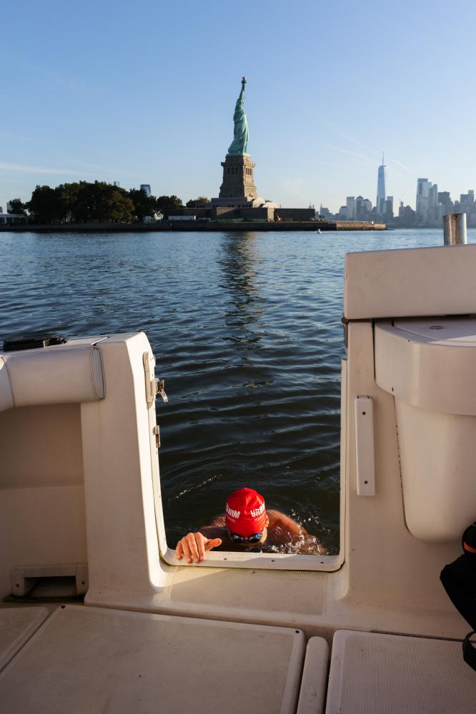 A swimmer rests on the stern of... of the harbor’s water quality.