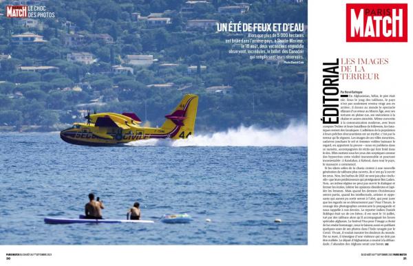 Holiday makers paddle while a water-dumping aircraft fills its tanks with water in the bay in Sainte-Maxime, southern France, Wednesday, Aug. 18, 2021. A wildfire near the French Riviera has killed one person and remained out of control as it raged through forests for a third day Wednesday, according to authorities. Ref: 22596933_000013