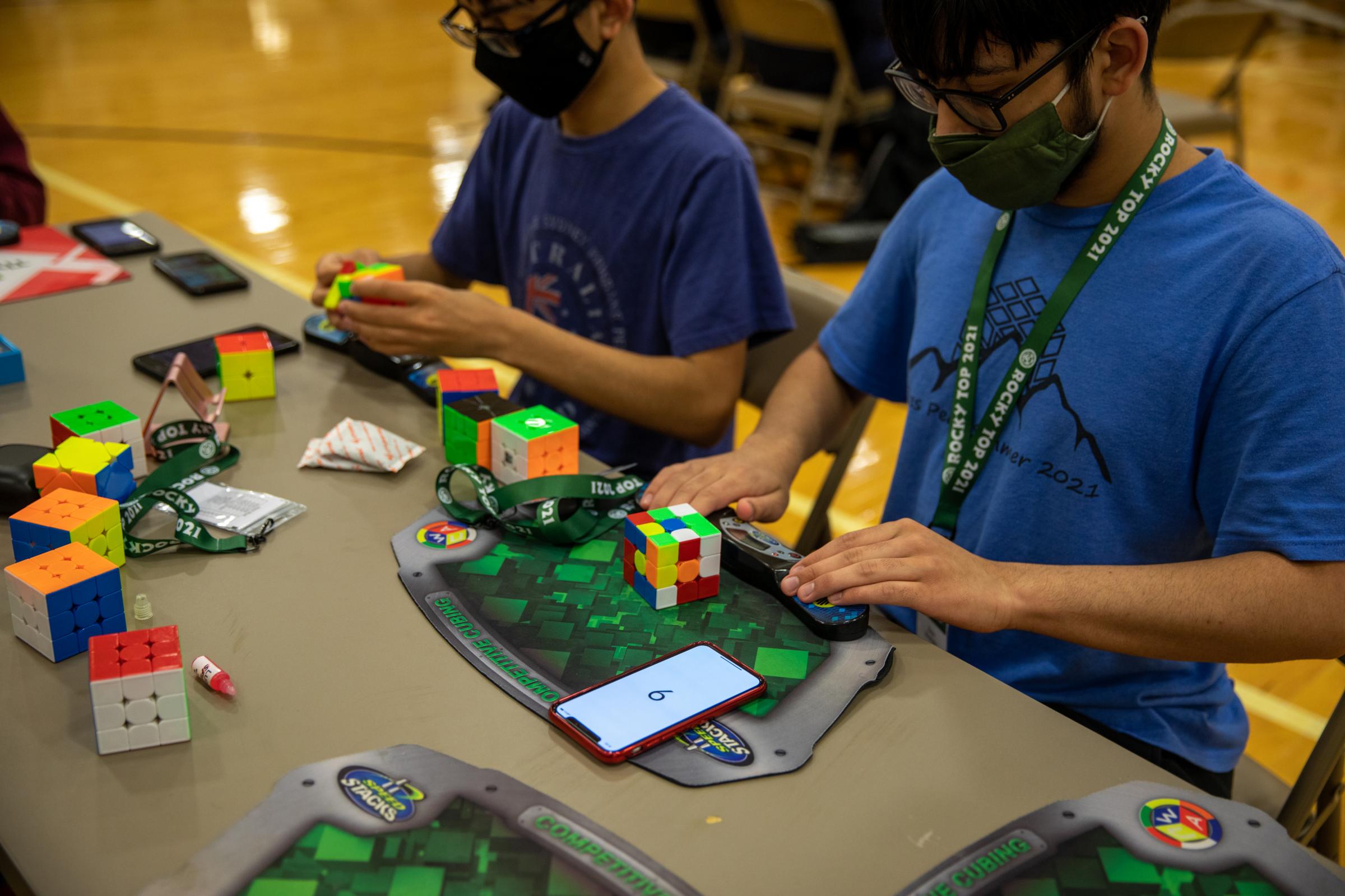 Speedcubers - Competitors practice at tables throughout the competition using their own speed cubing timer and...