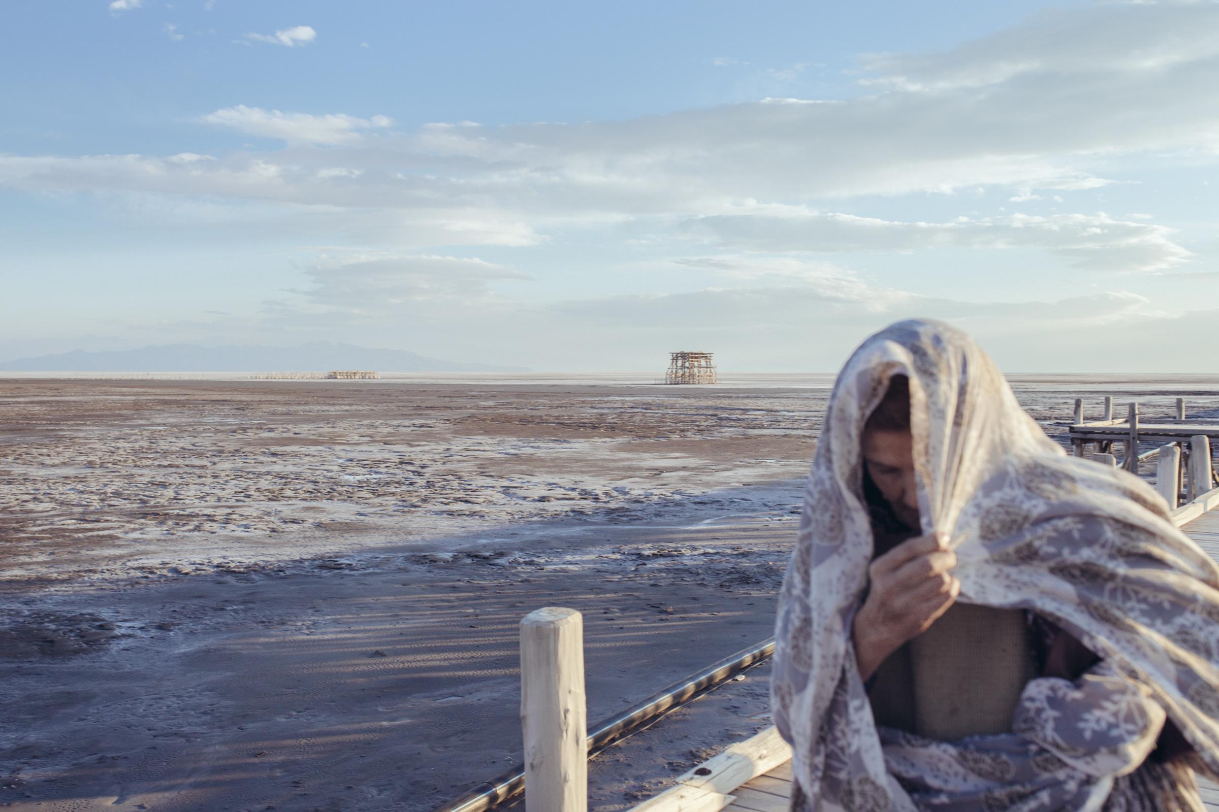 THE EYES OF EARTH (THE DEATH OF LAKE URMIA 2014-ONGOING) -   Grandmother, Narges, seen here in 2015, walks on a pier...