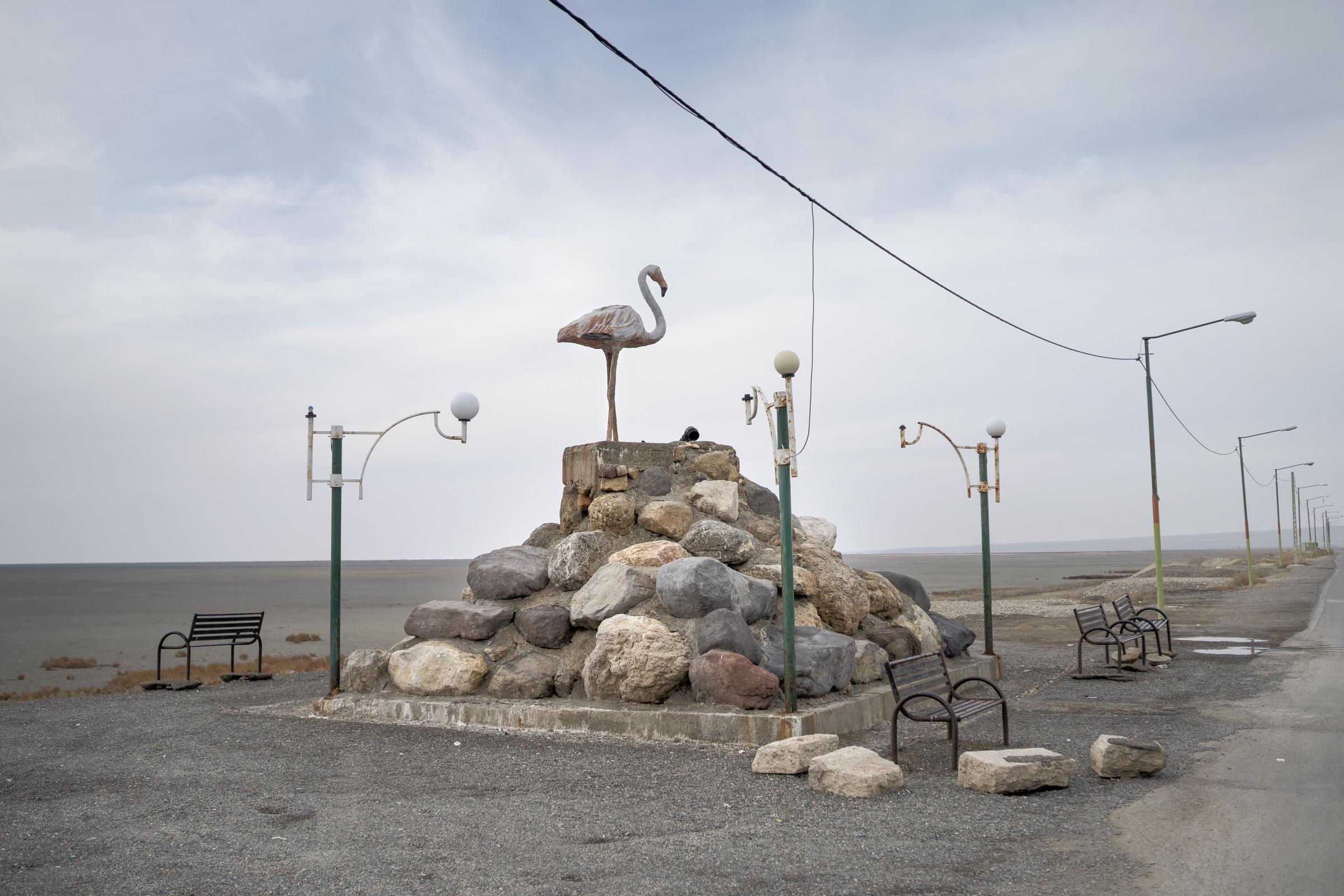 THE EYES OF EARTH (THE DEATH OF LAKE URMIA 2014-ONGOING) -   A concrete Flamingo statue in an eerie and apocalyptic...
