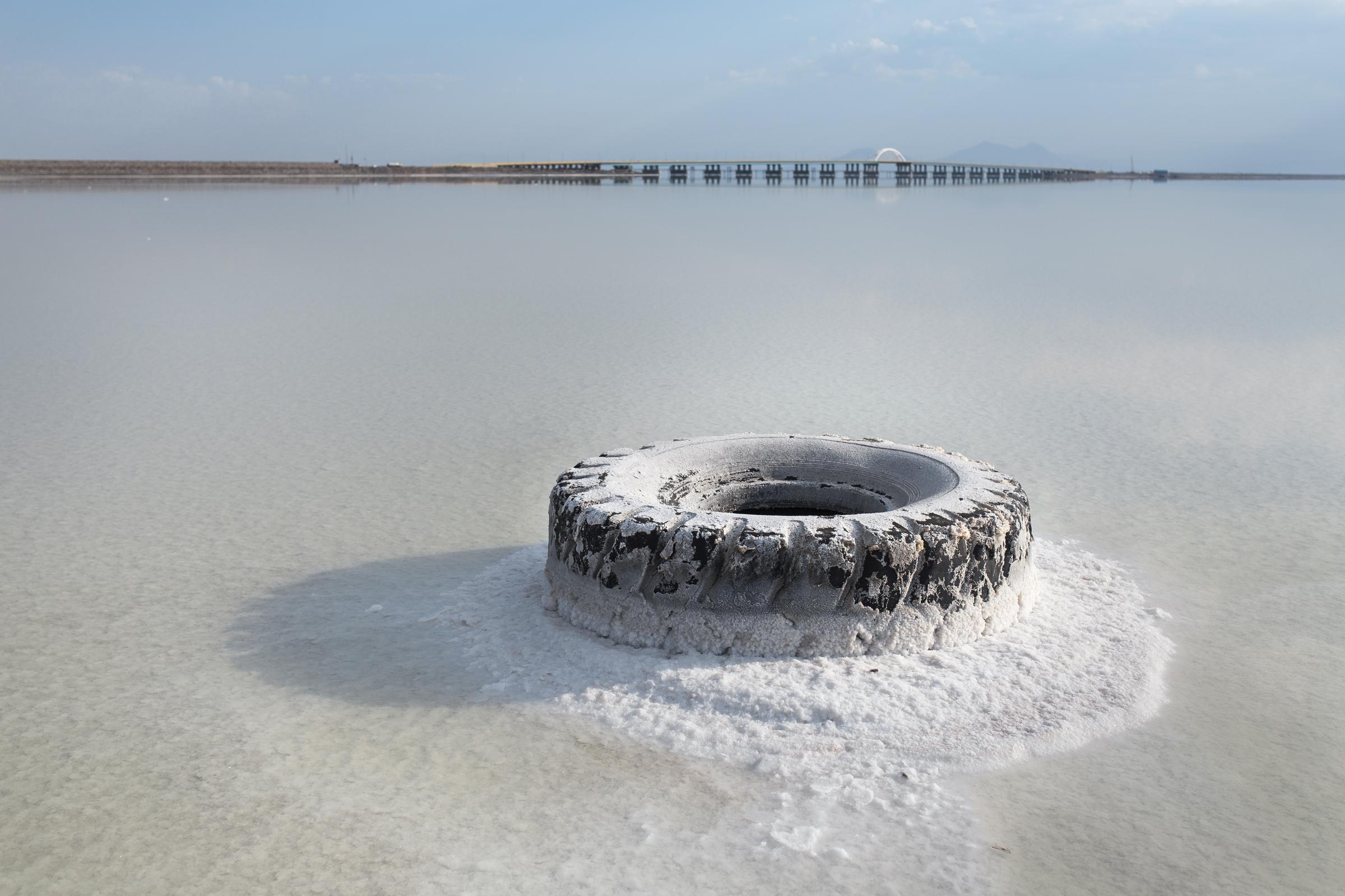 THE EYES OF EARTH (THE DEATH OF LAKE URMIA 2014-ONGOING) -   A tire covered in salt on the coastline at the...