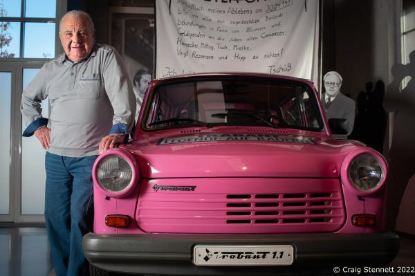 ZWICKAU, GERMANY- NOVEMBER 07: Roland Schulze, a former production line worker for the Trabant in the time of the GDR stands by the last Trabant to come off the production line at the August Horch Museum in Zwickau, Saxony, Germany in 2019. Often referred to as &quot;a spark plug with a roof&quot; Trabants were constructed from a hard plastic body mounted on a one-piece steel chassis and not from compressed cardboard as is often rumoured. It had front-wheel drive, a transverse engine, and independent suspension which were unusual and innovative production features for the time. The first Trabant rolled out of the &quot;VEB Sachsenring Automobilwerke Zwickau&quot; factory in Saxony, Eastern Germany on 7 November 1957. All the various models of Trabant were built in Zwickau, totalling 3,096,999 completed cars. This iconic car is often seen as symbolic for the GDR. The production finally stopped 1990 following German re-unification. In the early &#39;90s it was possible to buy a Trabi for a few Deutschmarks. Prices later recovered as the Trabi gained cult status. Today Trabants are starting to fetch prices equivalent with other classic cars. (Photo by Craig Stennett/Getty Images)