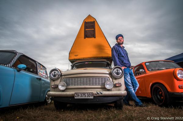 ZWICKAU, GERMANY- SEPTEMBER 01: Andreas Liebezeit at the Trabant Club Zwickau annual gathering of Trabi owners in Zwickau, Saxony in 2018. The German national now working in Switzerland, drove his Trabant P601, made in 1986, from his home in Zurich to Moscow, travelling through Poland and Lithuania. The return trip took him through the Ukraine and Czechoslovakia, a total of 6300 kilometers in 2 weeks: &quot;The beauty of the Trabant is its mechanical simplicity. You can repair it at the side of the road yourself.&quot; He also sleeps in the original roof tent designed in the DDR (Deutsch Democratic Republic) for the Trabant. The top and sides of the tent fold down onto a solid wood flooring bolted to the car&lsquo;s frame. The first Trabant rolled out of the VEB Sachsenring Automobilwerke Zwickau factory in Saxony, Eastern Germany, on 7 November 1957. All the various models of Trabant were built in Zwickau, totalling 3,096,999 completed cars. This iconic car is often seen as symbolic for the GDR. The production finally stopped 1990 following German re-unification. Often referred to as &quot;a spark plug with a roof&quot; Trabants were constructed from a hard plastic body mounted on a one-piece steel chassis and not from compressed cardboard as is often rumoured. It had front-wheel drive, a transverse engine, and independent suspension which were unusual and innovative production features for the time. In the early &#39;90s it was possible to buy a Trabi for a few Deutschmarks. Prices later recovered as the Trabi gained cult status. Today Trabants are starting to fetch prices equivalent with other classic cars. (Photo by Craig Stennett/Getty Images)