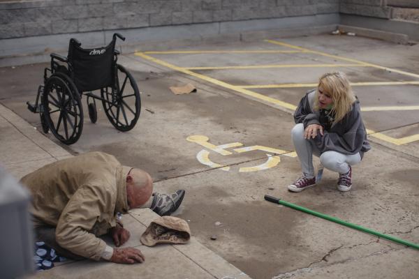 Behavioral health responder Leigh White speaks to a man who was hunched after he fell from his wheelchair in Albuquerque, NM on September 28, 2021. White is with the Albuquerque Community Safety program, a new arm of first responders available to address calls of low acuity such as those involving people with mental health and housing vulnerabilities.