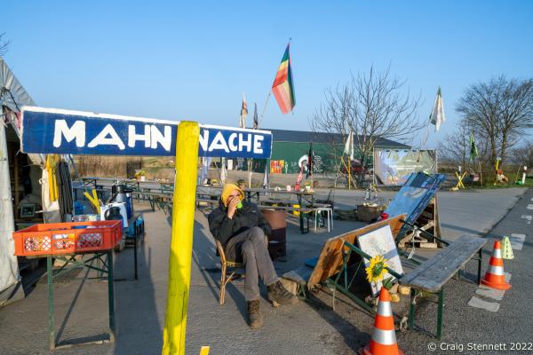 L&Uuml;TZERATH, GERMANY- MARCH 24: A protester sitting at the entrance to the environmental protest camp of &#39;Mahnwache L&uuml;tzerath&#39; on March 24, 2022 in L&uuml;tzerath, Nordrhein-Westfalen, Germany. The environmental camp was set up in 2020 on the land of L&uuml;tzerath Farmer Eckart Heukamp to protest against the expansion of the Garzweiler open-cast lignite mine. Most of the former properties in L&uuml;tzerath have already been demolished to make way for the mine but Eckart Heukamp has contested the RWEs (the energy provider who owns the mine) right to forcibly take his farm. The case is currently progressing through the German court system. (Photo by Craig Stennett/Getty Images)