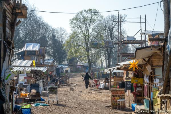 L&Uuml;TZERATH, GERMANY- MARCH 24: A protester walks through the environmental protest camp of &#39;Mahnwache L&uuml;tzerath&#39; on March 24, 2022 in L&uuml;tzerath, Nordrhein-Westfalen, Germany. The environmental camp was set up in 2020 on the land of L&uuml;tzerath Farmer Eckart Heukamp to protest against the expansion of the Garzweiler open-cast lignite mine. Most of the former properties in L&uuml;tzerath have already been demolished to make way for the mine but Eckart Heukamp has contested the RWEs (the energy provider who owns the mine) right to forcibly take his farm. The case is currently progressing through the German court system. (Photo by Craig Stennett/Getty Images)