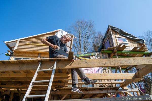 L&Uuml;TZERATH, GERMANY- MARCH 24: An enviromental protester working on the construction of a community building for the environmental protest camp of &#39;Mahnwache L&uuml;tzerath&#39; on March 24, 2022 in L&uuml;tzerath, Nordrhein-Westfalen, Germany. The environmental camp was set up in 2020 on the land of L&uuml;tzerath Farmer Eckart Heukamp to protest against the expansion of the Garzweiler open-cast lignite mine. Most of the former properties in L&uuml;tzerath have already been demolished to make way for the mine but Eckart Heukamp has contested the RWEs (the energy provider who owns the mine) right to forcibly take his farm. The case is currently progressing through the German court system. (Photo by Craig Stennett/Getty Images)