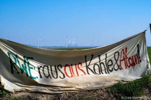 L&Uuml;TZERATH, GERMANY- MARCH 24: An enviromental protest banner saying &#39;gone with coal and atomic&#39; at the environmental protest camp of &#39;Mahnwache L&uuml;tzerath&#39; on March 24, 2022 in L&uuml;tzerath, Nordrhein-Westfalen, Germany. The lignite fired Neurath Power Station can be seen in the background. The environmental camp of &#39;Mahnwache L&uuml;tzerath&#39; was set up in 2020 on the land of L&uuml;tzerath Farmer Eckart Heukamp to protest against the expansion of the Garzweiler open-cast lignite mine. Most of the former properties in L&uuml;tzerath have already been demolished to make way for the mine but Eckart Heukamp has contested the RWEs (the energy provider who owns the mine) right to forcibly take his farm. The case is currently progressing through the German court system. (Photo by Craig Stennett/Getty Images)