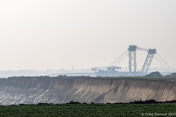 L&Uuml;TZERATH, GERMANY- MARCH 25: A coal mining machine in the Garzweiler lignite open cast mine on March 25, 2022 near the village of L&uuml;tzerath, Nordrhein-Westfalen, Germany. In the background is the village of Keyernberg. An enviromental camp &#39;Mahnwache L&uuml;tzerath&#39; (Vigil L&uuml;tzerath) was set up in 2020 on the land of L&uuml;tzerath Farmer Eckart Heukamp to protest against the expansion of the Garzweiler open-cast lignite mine. Most of the former properties in L&uuml;tzerath have already been demolished to make way for the mine but Eckart Heukamp has contested the RWEs (the energy provider who owns the mine) right to forcibly take his farm. The case is currently progressing through the German court system. (Photo by Craig Stennett/Getty Images)