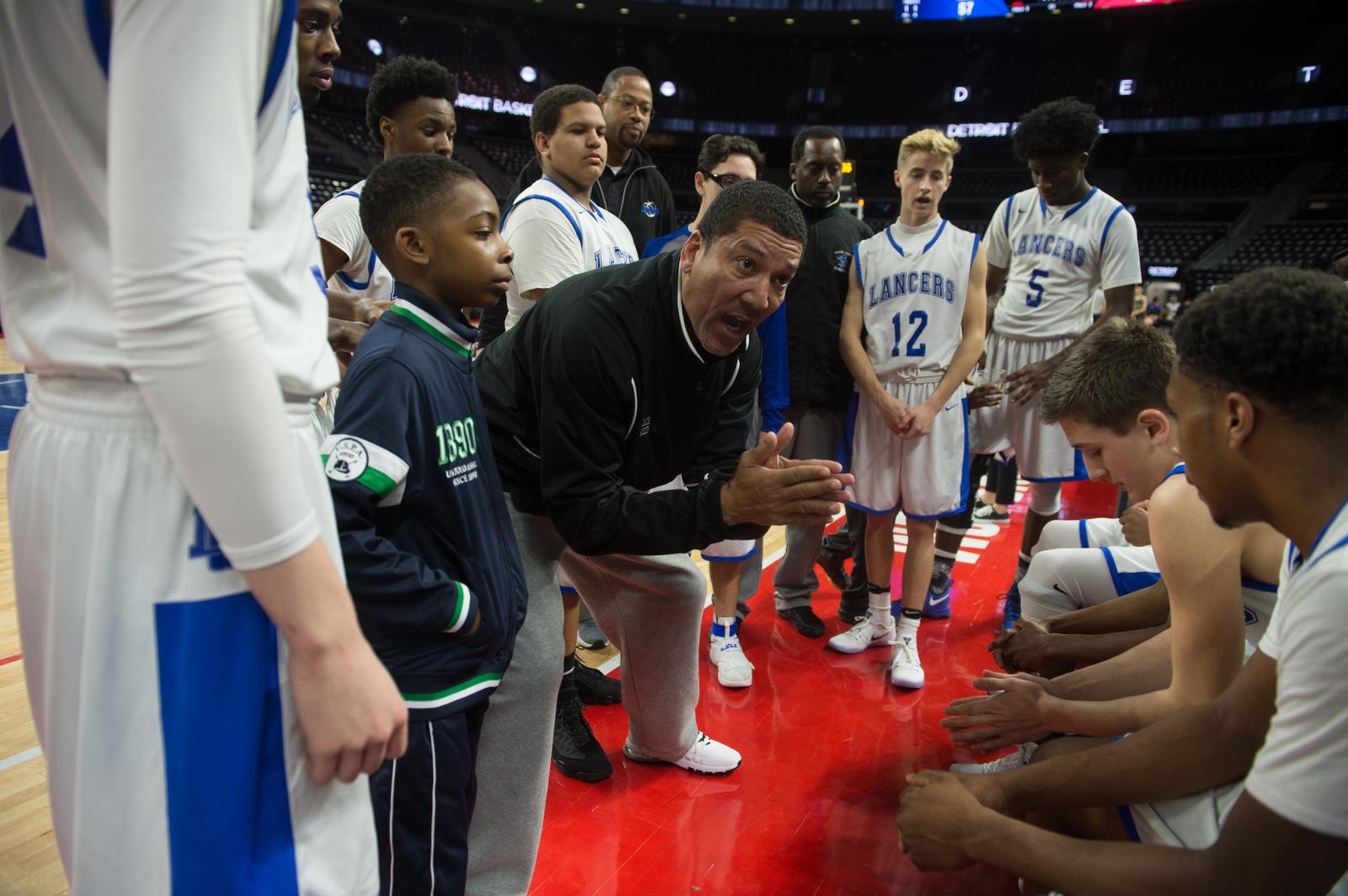 L&#39;anse Creuse High School basketball coach George Woods talks to his players late in the...
