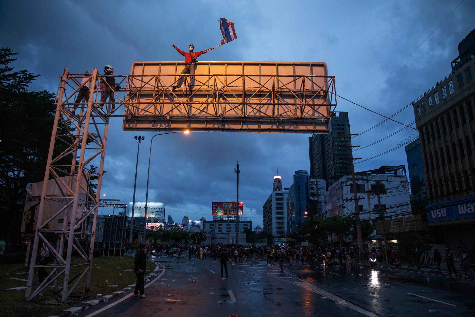 Thailand's Youth Fights Back - A pro-democracy protestor waves a Thai flag in the...