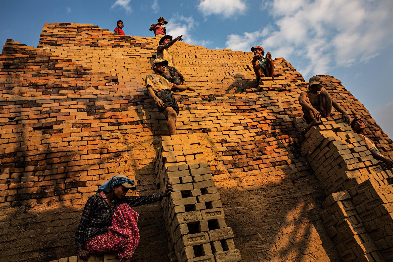  Workers stand on the face of a...Yangon, Myanmar, January 2015. 