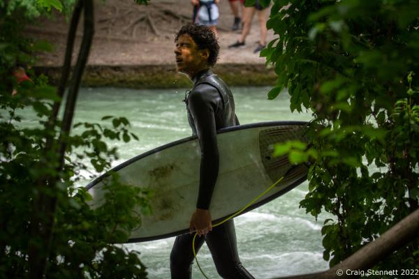 MUNICH, GERMANY - JUNE 15: A surfer walks back to the &#39;Standing Wave&#39; of the Eisbachwelle in Munich, Bavaria in 2019. The Eisbach (Ice Brook) is a 2 kilometer man made river which is in effect a canal tributary from Bavaria&lsquo;s Isar River. It runs through Munich&lsquo;s Englischer Garten, a public park, and is the hub of the land locked city&rsquo;s surf scene The river, following enhancement from local surfers, produces a standing wave called the Eisbachwelle (Ice Brook Wave). It has been surfed in the city since the early 1970&rsquo;s. Munich now claims to be home to some 2000 full time surfers. (Photo by Craig Stennett/Getty Images)