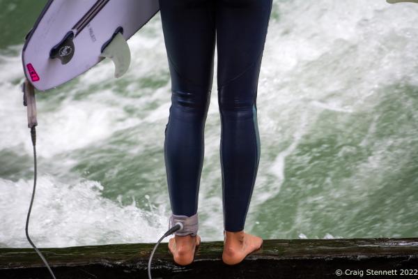 MUNICH, GERMANY - JUNE 15: A surfer stands at the shore of the Eisbachwelle in Munich, Bavaria in 2019. The Eisbach (Ice Brook) is a 2 kilometer man made river which is in effect a canal tributary from Bavaria&lsquo;s Isar River. It runs through Munich&lsquo;s Englischer Garten, a public park, and is the hub of the land locked city&rsquo;s surf scene The river, following enhancement from local surfers, produces a standing wave called the Eisbachwelle (Ice Brook Wave). The cool waters and fast current of the Eisbach will drag a surfer down stream for around 40 meters after they&lsquo;ve come off their board from the original &#39;Standing Wave&#39; before they can catch their footing. It has been surfed in the city since the early 1970&rsquo;s. Munich now claims to be home to some 2000 full time surfers. (Photo by Craig Stennett/Getty Images)