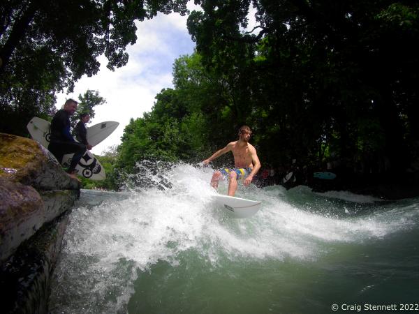 MUNICH, GERMANY - JUNE 15: Surfing The Eisbach (Ice Brook) in Munich, Bavaria, Germany in 2019. The Eisbach is a 2 kilometer man made river in Munich and it is the hub of the land locked city&rsquo;s surf scene. It is situated beneath a bridge just past the Haus der Kunst on Prinzregentenstrasse, at the southern edge of the Englischer Garten, Munich&#39;s largest public park. The river forms a standing wave which has been aided by surfers adding wooden planks to the flow of the current. The Eisbach has been surfed since the early 1970&#39;s and the City of Munich now claims some 2000 full time surfers coming from diverse economic, age and social backgrounds. (Photo by Craig Stennett/Getty Images)