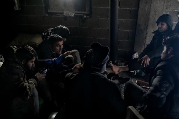 Image from Stranded - Bihac/Bosnia-Herzegovina - A group of Afghan refugees warming themselves inside an...