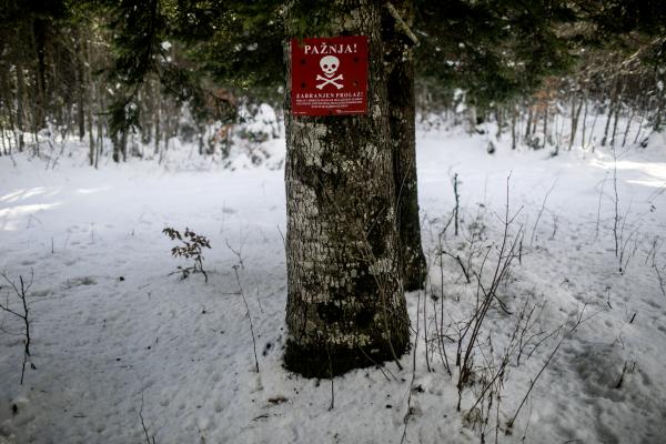 A sign warning of landmines in the woods of Prsine Uvale mountain, near the Bosnian-Croatian border, at the outskirts of the city of Bihac, Bosnia. Many refugees try to cross the border into Croatia via a route in the woods of the mountain. risking their lives walking in areas where landmines are scattered, remnants from the 1990&#39;s civil war in the country.