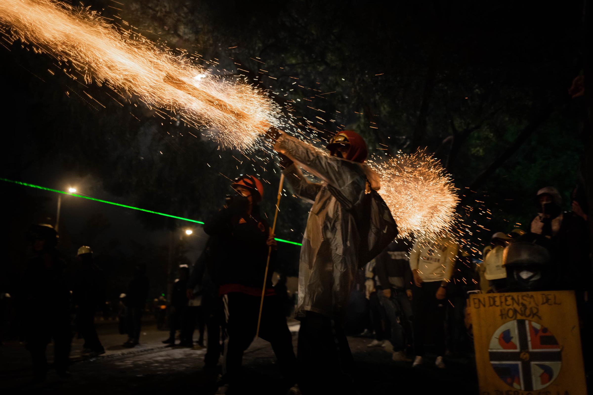 2021 in pictures - Colombian protesters launch a firework in the direction of ESMAD (mobile anti-disturbance...