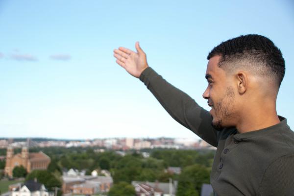 The Daily Orange - Angel Gonzalez points at the city of Syracuse spanning before him while explaining the history of...