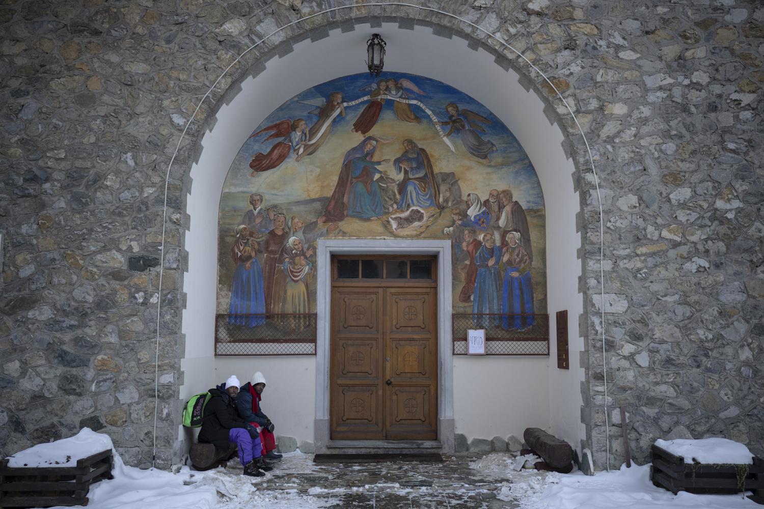 Ethiopian migrants take shelter under a church entrance in the Italian border town of Claviere...