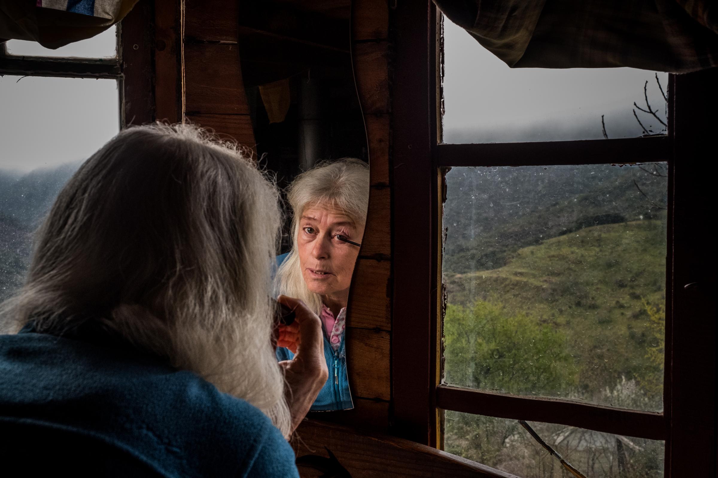 Hannah Br&uuml;derer brings on make-up in a wooden yurt in Matavenero, Spain. Matavenero is one of Spain&#39;s oldest repopulated villages, founded in the seventies by a group of German hippies. 50 years later, there are still 50 residents in the off-grid village, that only can be reached by foot. Hannah is among the founders of the village. Part of the project Rutopia, on the repopulation of abandoned villages in rural Spain, funded by the National Geographic Society. Matavenero, 3-4-2021