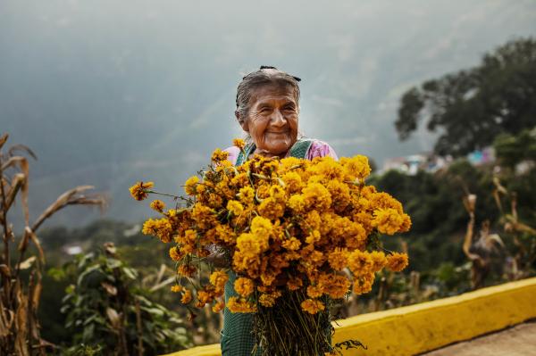 &quot;Se&ntilde;ora y cempazuchitl&quot; features a se&ntilde;ora carrying a bouquet of marigolds to the cemetery during the Day of the Dead in the town of Mazatlan Villa de Flores, Oaxaca, Mexico.