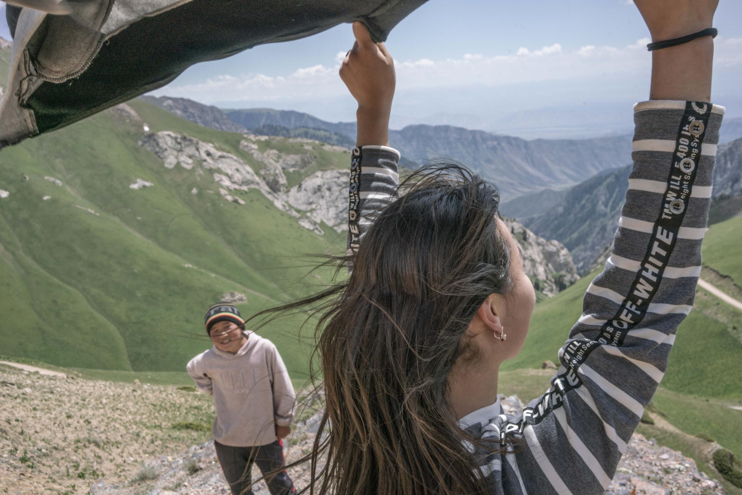 Nomads - Alina (20) and Tarstan look down into the steep mountain pass leading up to Song Kol Lake. Song...