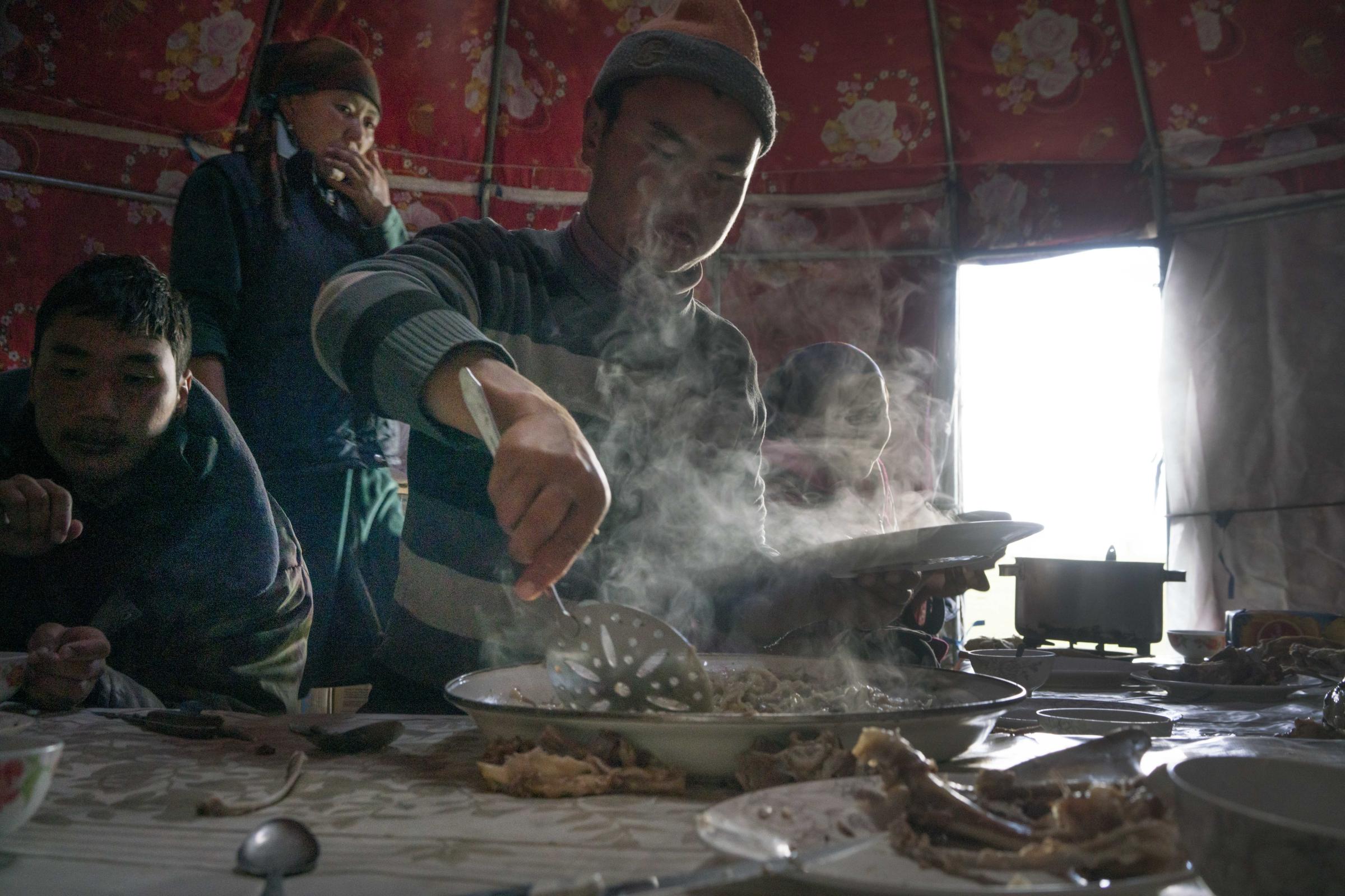 Nomads - A meal of freshly slaughtered mutton is served to guests from a neighboring yurt camp. Seating...