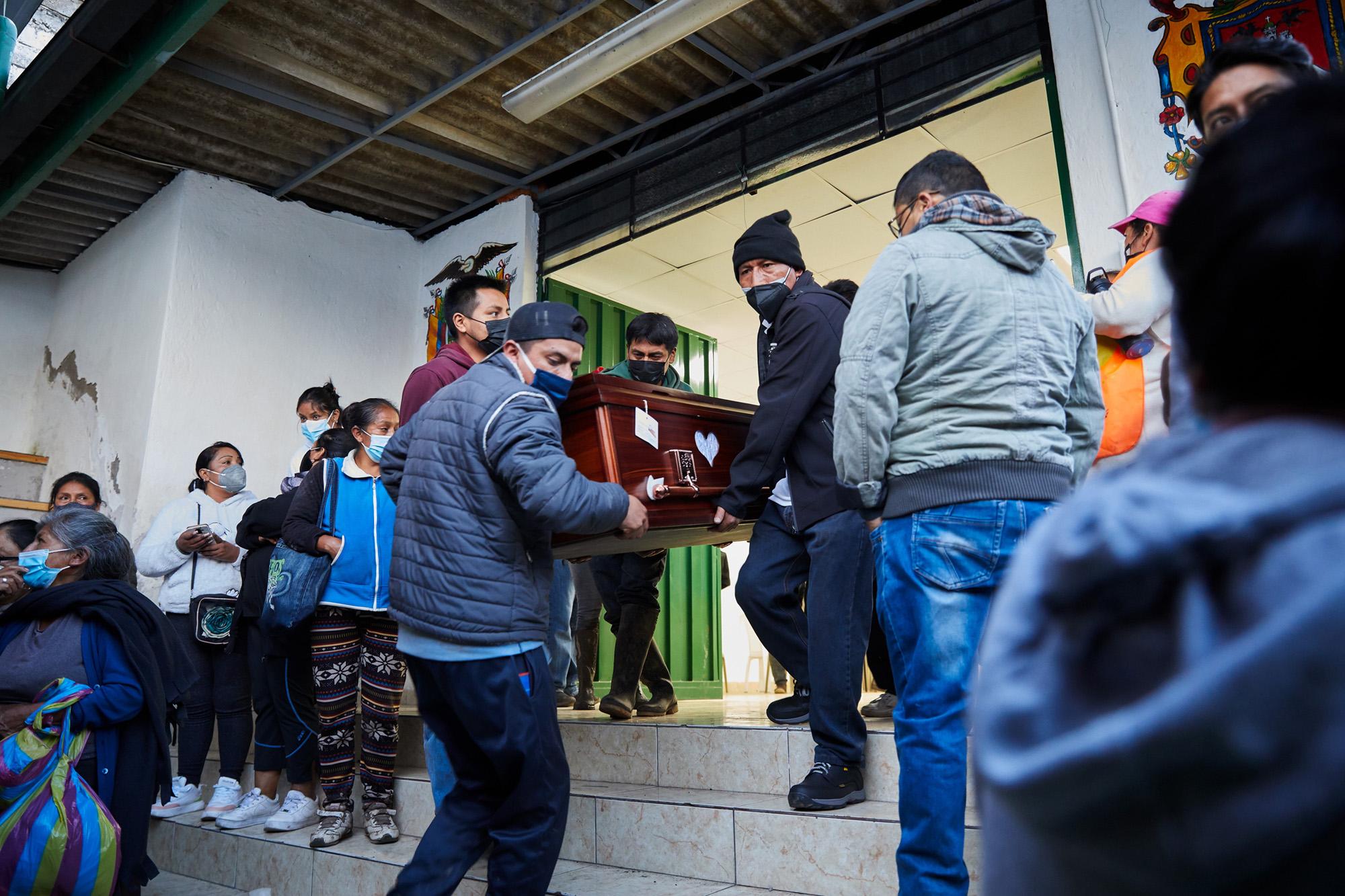 Residents of the La Comuna neighborhood take out some coffins of deceased persons after a...