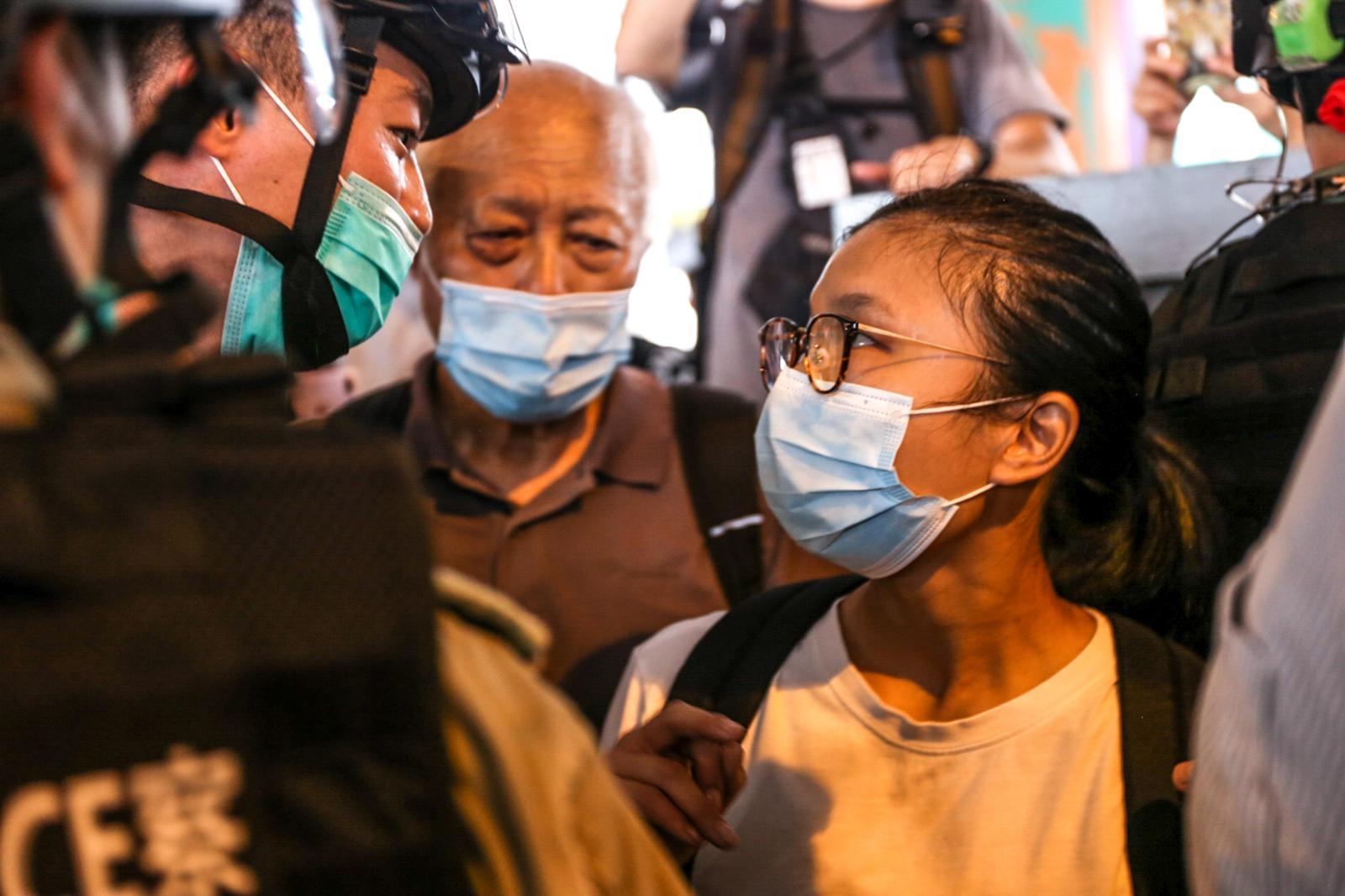 On the first day of the National Security Law, a young police officer mocks a young teenage girl on the streets of Hong Kong, as an elderly protestor looks on. Her unwavering stare is one of confrontation and definance, refusing to back down from the police officer. Since the eruption of protests in Hong Kong from 2019-2020, the reputation of Hong Kong police have dropped to its lowest point, receiving the least popularity of all disciplinary forces.