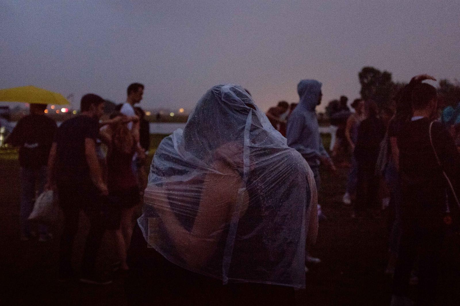 The Lovers II. A couple kisses as they share a rain cape at a dance event on Tempelhofer Feld. For many, summertime has been a welcome return to some type of normalcy in the Coronavirus pandemic. Berlin, August 2021.