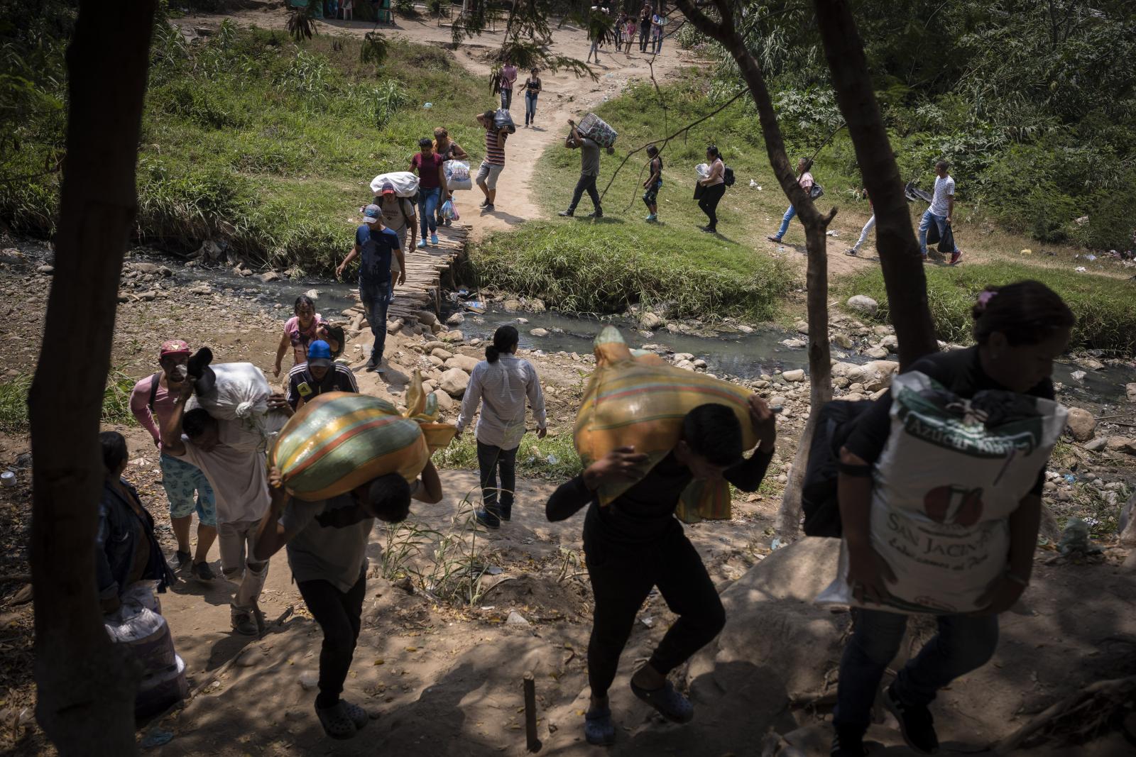 A group of Venezuelans cross the border through an illegal crossing from Colombia to the city of...