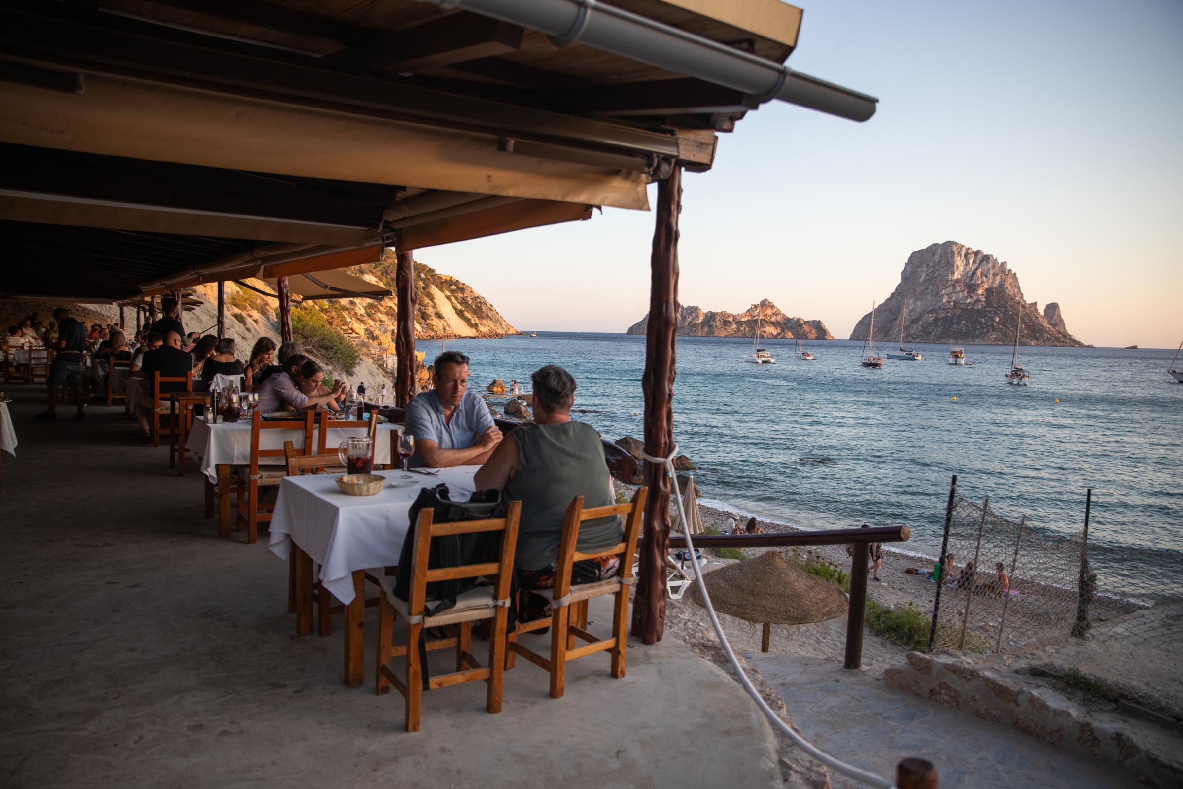 Covid-19: Ibiza Added To UK Amber Travel List - IBIZA, SPAIN - JULY 16: People dine in front of the sea...