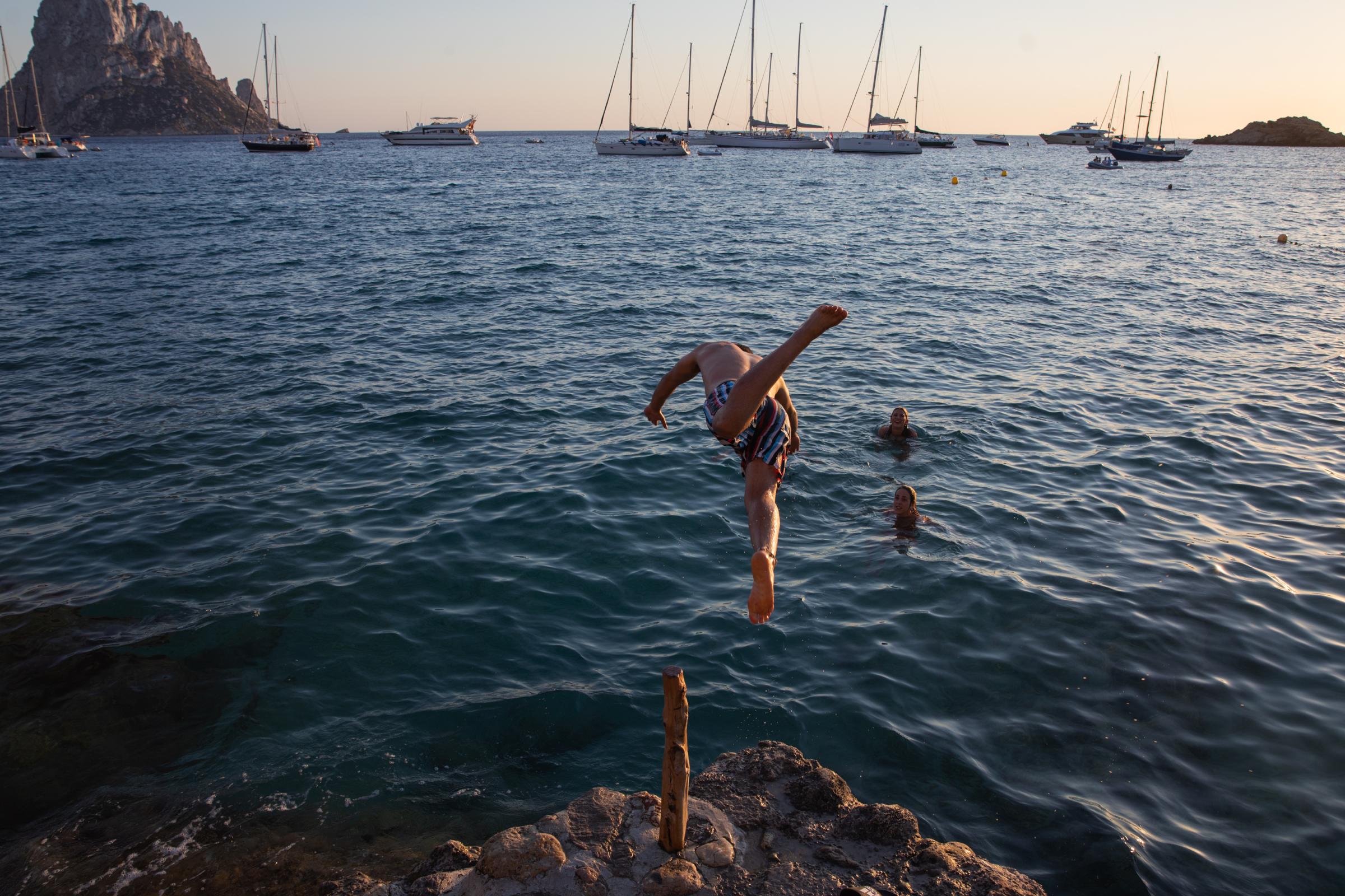 Covid-19: Ibiza Added To UK Amber Travel List - IBIZA, SPAIN - JULY 16: An unidentified young man jumps...