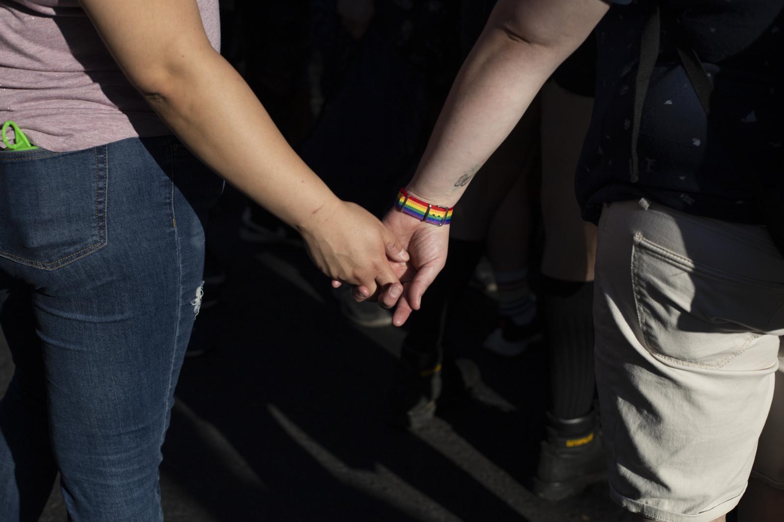 Dos personas se agarran de las manos durante la marcha por el orgullo LGBTIQA+ el 13 de noviembre...